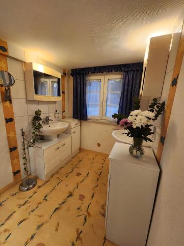a bathroom with two sinks and a vase of flowers at Alte Schmiede 2 Fewos in Feldberg