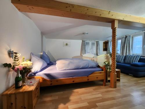 a bedroom with a bed and a blue couch at Alte Schmiede 2 Fewos in Feldberg