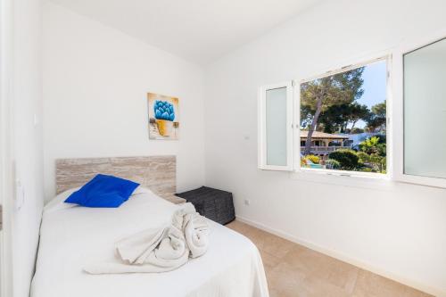 a white bedroom with a bed and a window at Trevol Suits in Cielo de Bonaire 