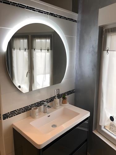 a bathroom with a sink and a mirror at Gîte Les Aubennes in Fromelennes