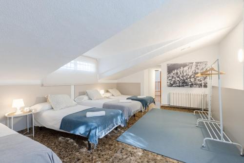 a bedroom with three beds and a blue rug at Fidalsa Paradise Pines in La Alcayna