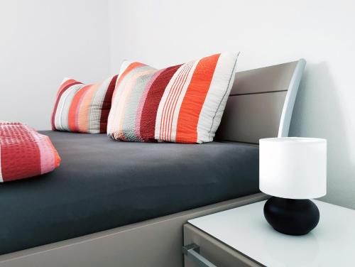 a bed with pillows and a table with a lamp at Fuchsbau in Baiersbronn
