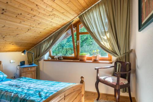 a bedroom with a bed and a window and a chair at Rose Garden in Heiligenberg