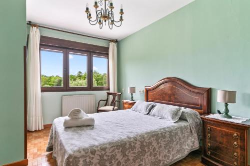 a bedroom with a large bed and a window at Ca Carmina in Colunga