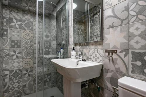 a bathroom with a sink and a shower and a mirror at Ca Carmina in Colunga