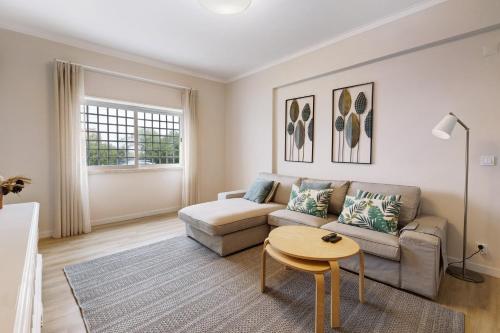 a living room with a couch and a table at Caparica Sun Beach Villa in Charneca