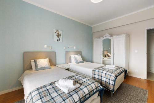 a bedroom with two beds and a mirror at Caparica Sun Beach Villa in Charneca
