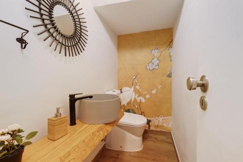 a bathroom with a toilet and a mirror on the wall at Caparica Sun Beach Villa in Charneca