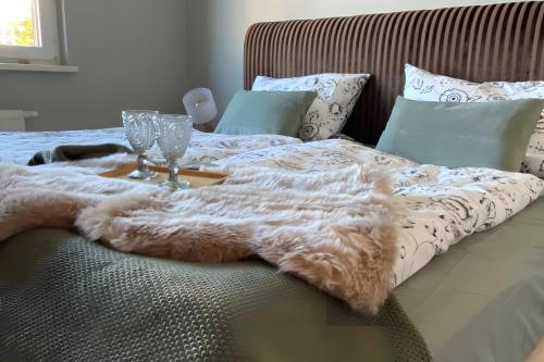 a bed with a fur blanket and glasses on it at Ferienhäuschen Gartenblick in Friedrichroda