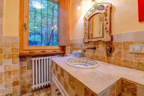 a bathroom with a sink and a mirror and a window at Colleincanto Appartamento Torretta in Gavardo