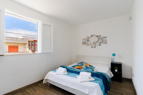 a white bedroom with a bed and a window at Casa Azzurra a Torre dell'Orso in Torre dell'Orso