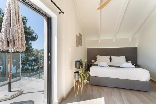 a bedroom with a bed and a large window at Mella Roa - Villa Onyx in Nydri