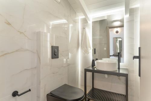 a white bathroom with a sink and a toilet at Mella Roa - Villa Onyx in Nydri