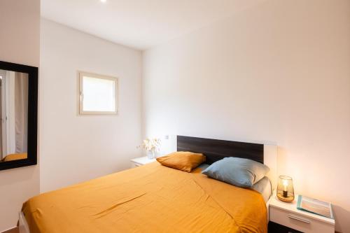 a bedroom with a yellow bed with two pillows at A Casa Assulanata Cinto in Santa-Reparata-di-Balagna
