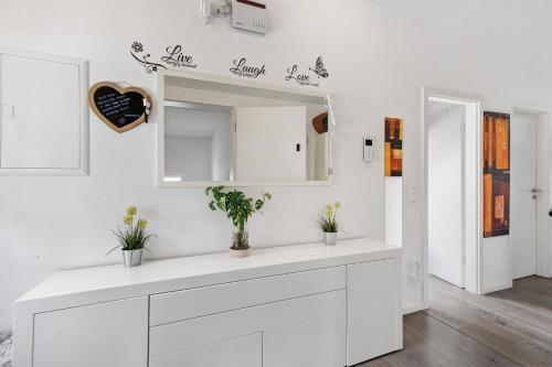 a white kitchen with a counter and a mirror at Ferienwohnung Bailey in Laupheim