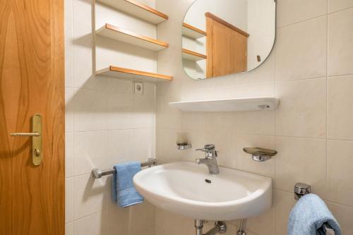 a bathroom with a sink and a mirror at Taufner Apartement A 105 in Parcines