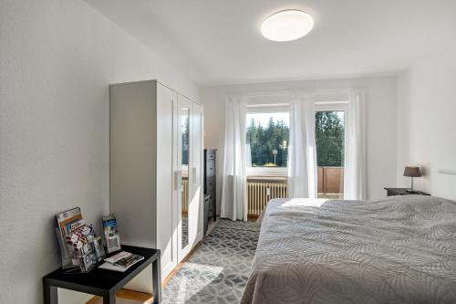 a white bedroom with a bed and a window at Ferienwohnungen Nordschwarzwald in Freudenstadt