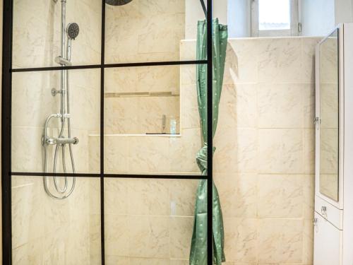 a shower stall with a glass door and a shower constructor at Le Cocon in Villalier
