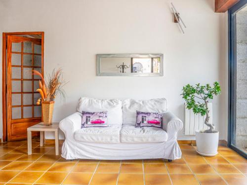 a white couch in a living room with pink pillows at Le Cocon in Villalier