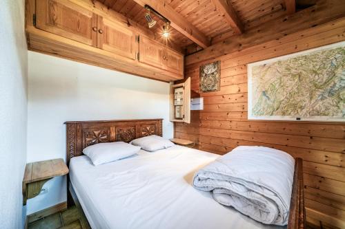 a bedroom with a bed in a wooden cabin at Chalet 6p Classique - L'Erable in Verchaix