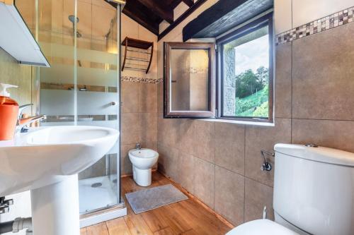 a bathroom with a sink and a toilet and a window at La Plazuca Cerrucao in Selaya