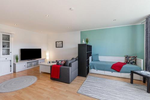 a living room with a bed and a tv at Ferienwohnung Sterl 13 in Herscheid