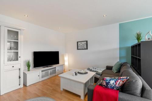a living room with a couch and a tv at Ferienwohnung Sterl 13 in Herscheid
