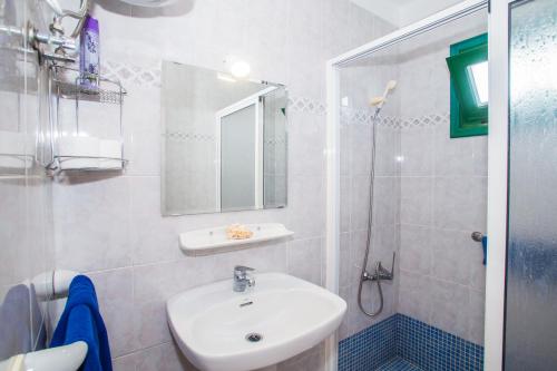 un bagno bianco con lavandino e doccia di Apartamentos Sal y Mar a Puerto del Carmen