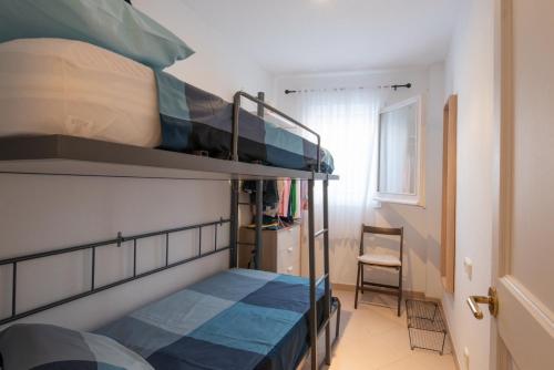 two bunk beds in a small room with a chair at Can Quintaneta in Begur