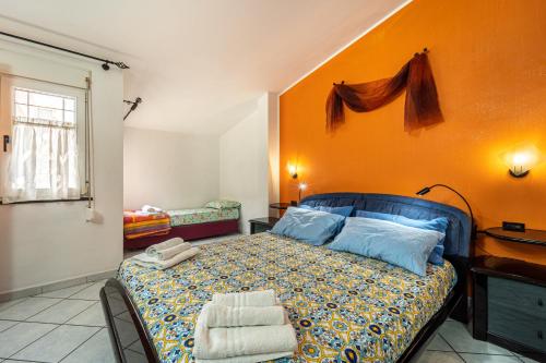 ein Schlafzimmer mit einem Bett und einer orangefarbenen Wand in der Unterkunft Casa Flu in Assemini