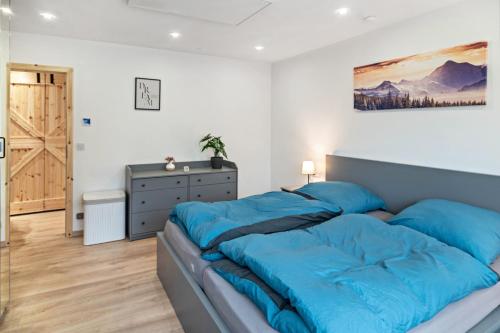 a bedroom with a large bed with blue sheets at Ferienwohnung Wittle in Weiler-Simmerberg