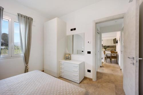 a white bedroom with a bed and a mirror at Antichi Ricordi - Da Angela in Marina di Andora