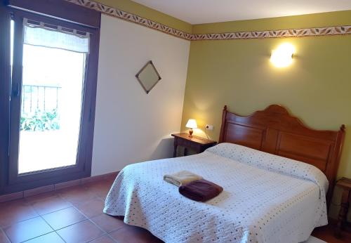 a bedroom with a bed with a white bedspread and a window at Lokate 2 Habitaciones in Aia