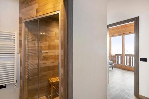 a glass shower door in a room with a balcony at Plaz in Livigno