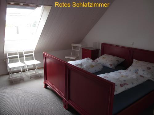 a bedroom with a bed and two chairs and a window at Ferienwohnung Stine in Stetten