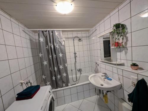 a bathroom with a shower and a sink and a tub at Wat Bickenbach in Bickenbach