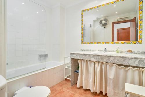 a bathroom with a sink and a tub and a toilet at Carabeo 19 in Nerja