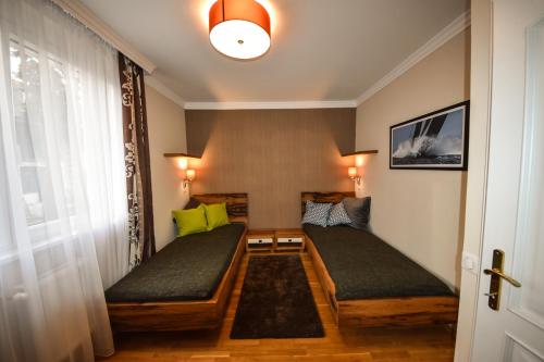 ブダペストにあるRosehill Side Apartmentのベッド2台と窓が備わる小さな客室です。