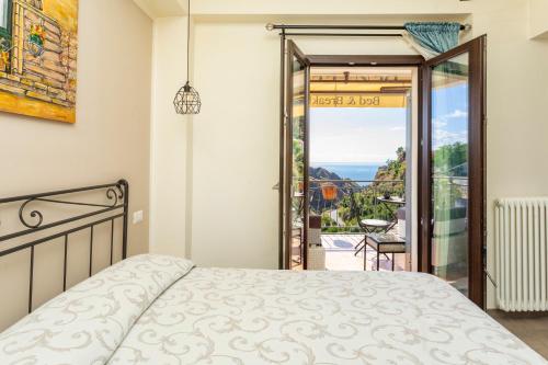a bedroom with a bed and a view of the ocean at Pentefur Suite Savoca in Savoca