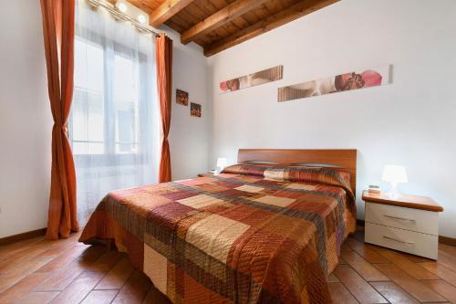 a bedroom with a bed and a large window at Casa Laura in Salò