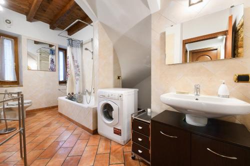 a bathroom with a sink and a washing machine at Casa Laura in Salò
