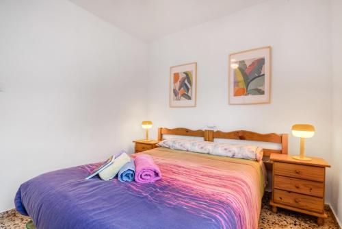 a bedroom with a bed and a night stand with two lamps at Manhattan in Oliva