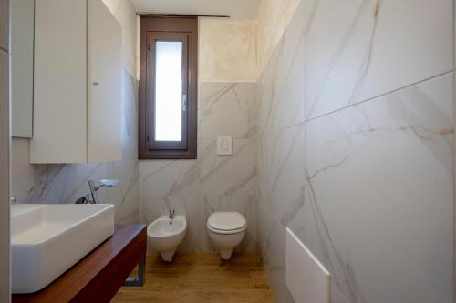 a bathroom with a sink toilet and a window at Villa Marzla in Cassano delle Murge