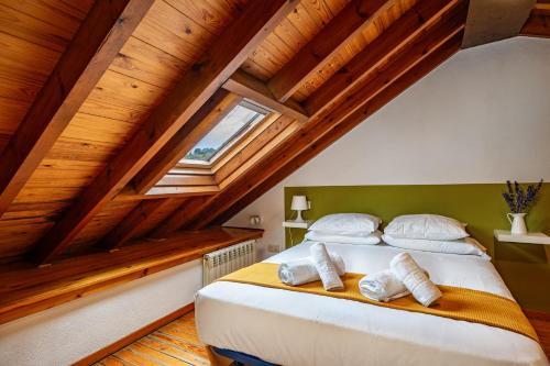 a bedroom with a large bed with wooden ceilings at Casa Florenta G4 in Cangas de Onís