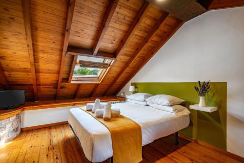 a bedroom with a large bed in a room with wooden ceilings at Casa Florenta G4 in Cangas de Onís