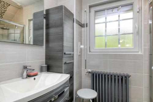 a bathroom with a sink and a toilet and a window at La Renardière - Chambre in Férel