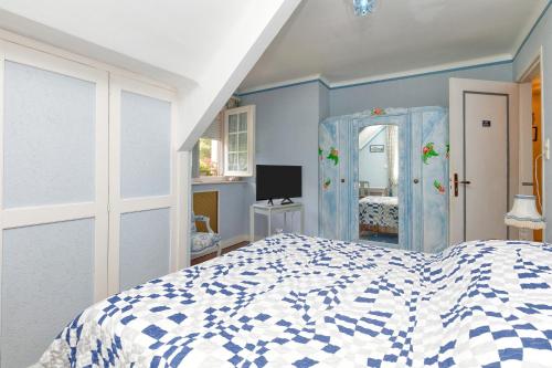 a bedroom with a blue and white bed and a mirror at La Renardière - Chambre in Férel