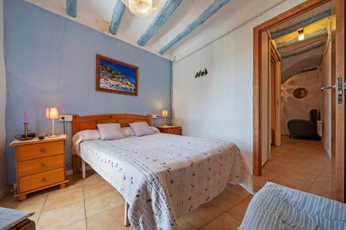 ein Schlafzimmer mit einem Bett, einer Kommode und einer Tür in der Unterkunft Cal Cosials in La Morera de Montsant