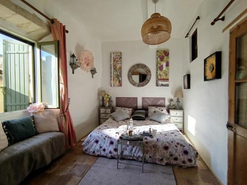 a bedroom with a bed and a couch and a table at Chambres D'hôtes La Buissonnière in Théziers