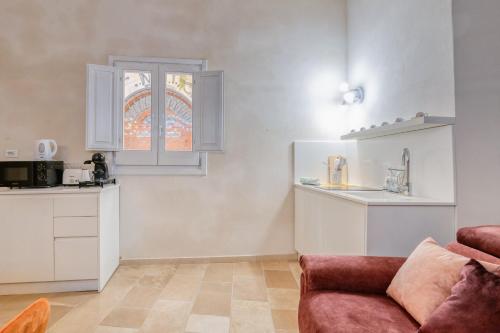 ein Wohnzimmer mit Sofa und eine Küche in der Unterkunft Antony Suite Strada in Lecce